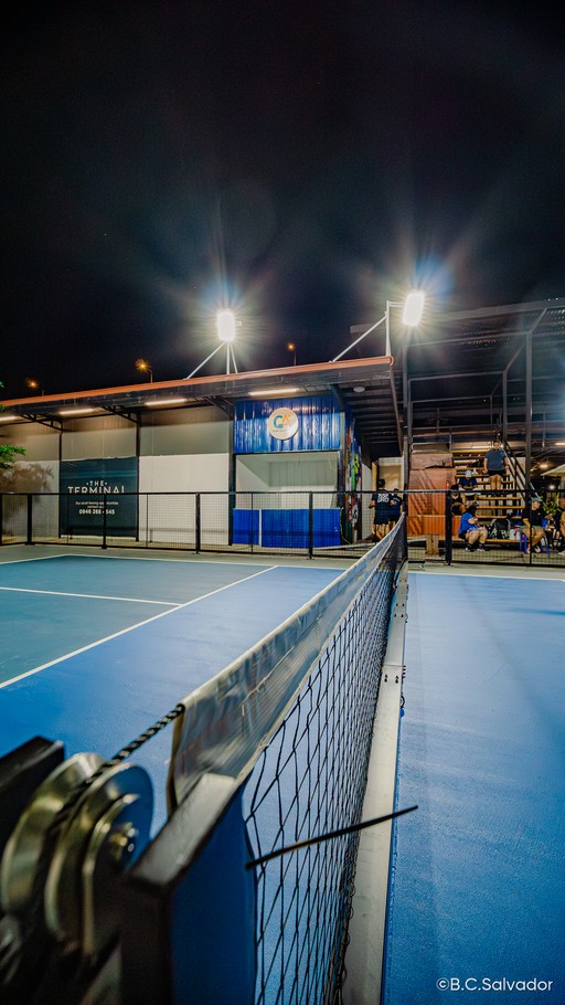 Night pickleball court with the net and Courtside Alley kiosk